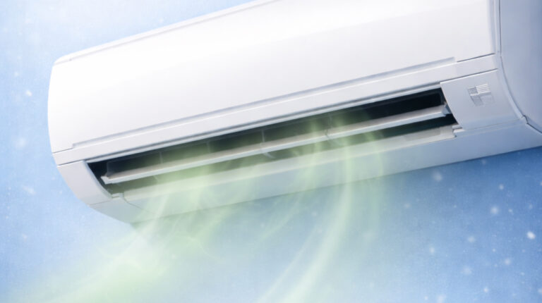 Wall-mounted air conditioner emitting airflow, representing common aircon smells like sour, musty, burnt, or fishy and their causes by Peakcool.